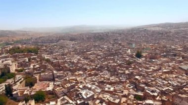 Fez, Fas hava manzarası, tarihi binalar, dolambaçlı sokaklar ve açık mavi gökyüzünün altında yayılan bir şehrin özünü yakalayan canlı bir kültürü gösteriyor.