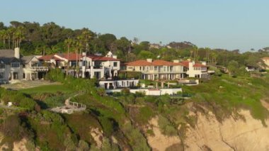 Günbatımında, Malibu, California 'daki nefes kesici lüks kıyı evleri üzerindeki nefes kesici 4K manzarasına hayran kalarak, seçkin mahallenin güzelliğini ve lüks yaşam tarzını gözler önüne seriyor.