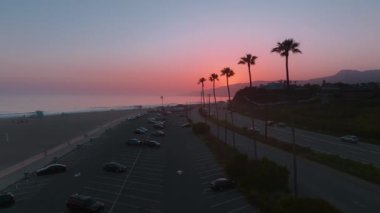 Günbatımında Malibu 'nun büyüleyici sahil şeridi, palmiye ağaçları ve huzur dolu sahil atmosferiyle büyüleyici bir hava perspektifinden bakıldığında Malibu' nun büyülü manzarasını izleyin.