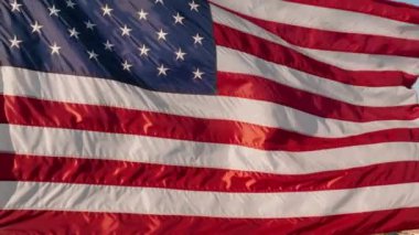 Amerikan bayrağı vatanseverliği ve gururu sembolize eder. Bağımsızlık, seçim ve ulusal bayramlar gibi konular için mükemmeldir. Bayrağın zarafetle dalgalandığı hava manzarası.