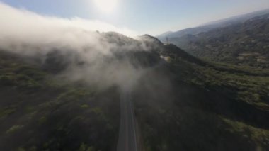 Malibu, California 'daki sisli bir dağ yolunun FPV insansız hava aracından çarpıcı bir görüntü. 4K görüntüsü manzaranın huzurlu güzelliğini yakalar, doğa severler için mükemmeldir..