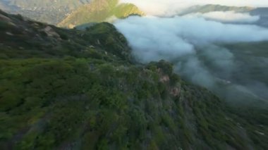FPV insansız hava aracı görüntüleri Malibu, California 'nın yeşil tepelerini deniz bulutları ve el değmemiş vahşi doğa da dahil olmak üzere doğal manzaraların çarpıcı hava manzaralarıyla yakalıyor.