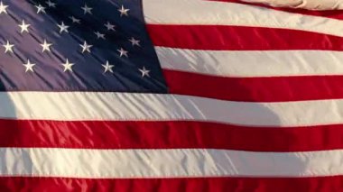 Gün batımında, Bağımsızlık Günü, seçimler ve diğer önemli ulusal olaylarla ilişkili vatanseverlik ve ulusal gururu simgeleyen bir Amerikan bayrağı görkemli bir şekilde dalgalanıyor..