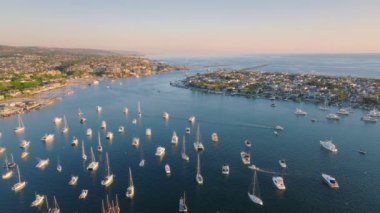 Newport Sahili, Kaliforniya hareketli bir limanı, tekneleri, kıyı şeridi ve berrak bir günbatımı gökyüzü ile nefes kesici bir hava manzarası sunar.