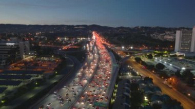 Bir hava görüntüsü, gece Los Angeles otoyolunda büyük bir trafik sıkışıklığını yakalıyor, şehir ışıkları ve araçlar görünür, Kaliforniya, ABD 'de kentsel sıkışıklık ve hareketli şehir yaşamını gösteriyor