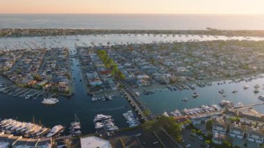 Newport Sahili, Kaliforniya 'daki sakin ve büyüleyici günbatımı manzarasında güzel bir marina, tekne ve sahil manzarası var. Rahatlamak ve keyif almak için güzel bir ortam sunuyor.