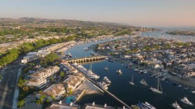 Newport Beach, California 'nın çarpıcı hava manzarası güzel sahil şeridini, marinasını ve açık mavi gökyüzünün altındaki büyüleyici yerleşim yerlerini gözler önüne seriyor.