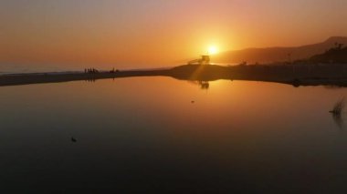 Malibu, California 'nın büyüleyici bir hava perspektifi okyanus üzerinde huzurlu bir gün batımı sergiliyor. Bu sahil cennetimizin doğal güzelliğini ve huzurlu atmosferini vurguluyor.