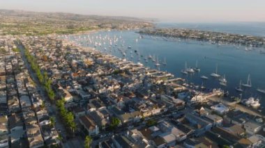 Newport Sahili, Kaliforniya 'nın muhteşem manzaralarını büyüleyici 4K hava perspektifinden keşfedin. Kıyı şeridinin, teknelerin, şehir manzarasının ve lüks deniz manzarasının güzelliğini yakalayın.
