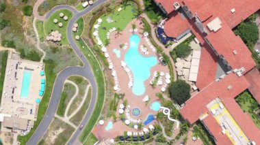 Nefes kesici 4K hava manzarası birden fazla havuzu, yemyeşil ve dolambaçlı yolları olan özel bir Laguna Sahili tatil köyünü gözler önüne seriyor.