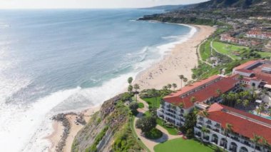 Bu havadan 4K görüntüsü, ABD 'nin Laguna Sahili üzerinde nefes kesen gündoğumunu yakındaki binalar ve yeşilliklerle kıyı manzarasını, kumlu plajları ve okyanus dalgalarını gözler önüne seriyor..