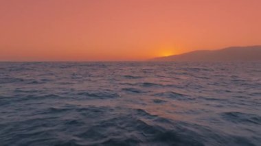 Nefes kesici bir hava manzarası 4K çözünürlük ve yavaş çekim ile deniz üzerinde zarif bir şekilde süzülen bir pelikan sürüsünü yakalar ve saniyede 120 kare ile doğanın barışçıl güzelliğini vurgular.