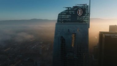Los Angeles, Kaliforniya, ABD - 21 Haziran 2024: Los Angeles şehir merkezinin canlı bir görüntüsü, sabah ışığında parlayan gökdelenleri ve gökyüzünü kaplayan sisleri gösteriyor.