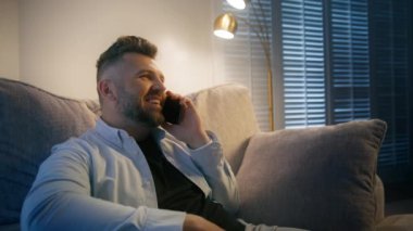 Sıcak bir ışıkla aydınlatılmış rahat bir koltukta rahat bir şekilde otururken bir erkek hoş bir telefon konuşması yapmaktan hoşlanır. Bu da odada çok rahat ve davetkar bir atmosfer yaratır.