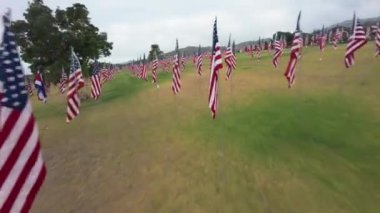 Bir FPV insansız hava aracı, çeşitli ulusları sembolize eden, 11 Eylül 2001 'deki trajik olayları onurlandıran ve bize ortak değerlerimizi hatırlatan 3000 renkli bayrağın çarpıcı bir görüntüsünü yakalıyor.