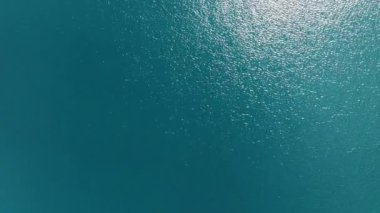 Sakin turkuaz bir su sergilenen sakin bir manzara huzurlu bir sahnede parlak güneş ışığını güzel yansıtıyor.