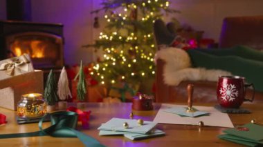 Bir kadın, rahat bir şömine, şenlikli süslemeler ve harika ışıklandırılmış bir ağacın yarattığı huzurlu Noel atmosferinden keyif alır. Bu da tatil sezonunun ruhunu güçlendirir.