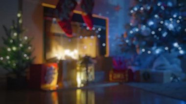 Arkaplan için odaksız çerçeve. Huzurlu bir Noel arifesi, sıcacık yanan bir şömine, ışıl ışıl bir Noel ağacı, ve düşünceli hediyeler, hepsi bayram cazibesi saçıyor. 4K görüntü. 
