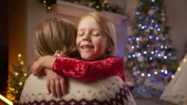 Sevgi dolu ve şefkatli bir anne, sevgili kızıyla Noel 'de parlayan şöminenin yanında paylaştığı değerli anı çok güzel bir şekilde kutlar. Kız annesinin kulağına 