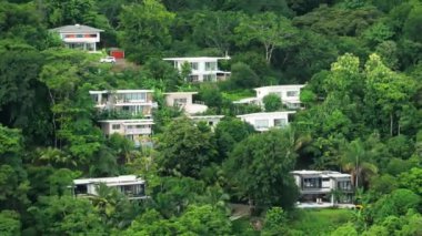 Kosta Rika 'nın canlı ormanlarında yuva yapmış modern evleri çeken bir hava fotoğrafı, çağdaş mimarinin çevre doğal çevreyle bütünleşmesini gözler önüne seriyor.
