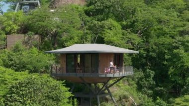 Bir baba ve küçük oğlu, Kosta Rika 'daki otel odalarının çarpıcı manzaraları karşısında heyecanlanıyor. Yeşilliklerle çevrili, tatilleri sırasında doğal huzurun tadını çıkarıyorlar.