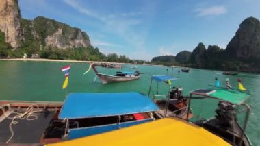 Krabi, Tayland - 29 Kasım 2024: Görkemli kayalıklar ve yemyeşil yeşilliklerle çevrili Krabis turkuaz sularında süzülen geleneksel uzun kuyruklu teknelerin havadan görünüşü.