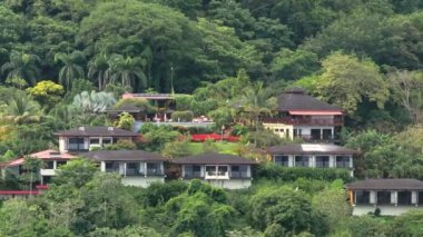 Kosta Rika 'nın yemyeşil ormanlarında yuva yapmış büyüleyici bir evin çarpıcı hava manzarasını deneyin. Güzel manzaranın zengin yeşillik ve huzur dolu çevresini vurgulayın.