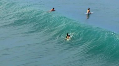 Bu hava fotoğrafı, Kosta Rika turkuvaz sularında mükemmel dalgalarla sörf yapan sörfçüleri yakalıyor ve çarpıcı bir sahile karşı tropikal sörfün heyecanını gösteriyor..