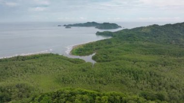 Bu hava fotoğrafı, Puntarenas, Kosta Rika 'nın canlı yeşillik ve altın sahil manzaralarını yansıtıyor. Tropik bir cennetin özünü yansıtıyor.