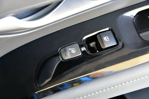The button for raising the windows and the button for heating the seats in the car