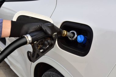 Refueling gun in tank filler. Fuel Nozzle in tank filler. Fuel pump in filler hole. 