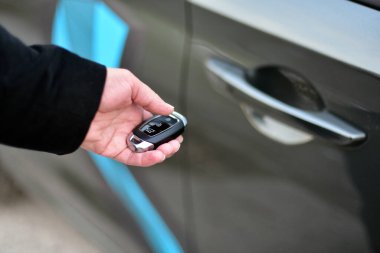 Bir kadın elinde bir arabanın anahtarını tutuyor.