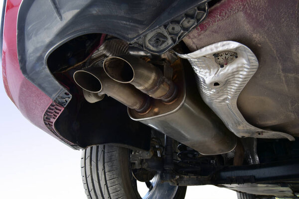 Exhaust and muffler on the lower part of the car