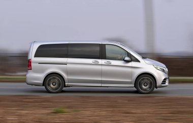 Bir yolcu kamyonu açık bir yolda yüksek hızda gider.