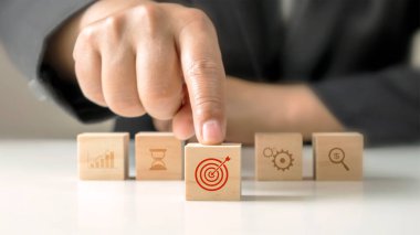 İşadamının elleri tahta bloklara basılı hedef tahtasını itiyor. Yatırım kavramı ve iş hedefleri belirlemek.