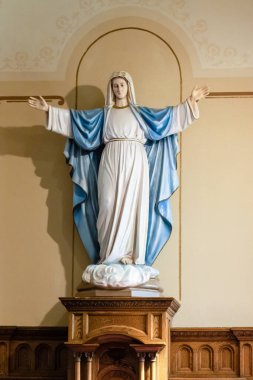 Kilisenin duvarına dayanmış Meryem Ana heykeli.