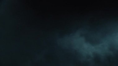 Atmosferik duman VFX elementi 4k ağır çekimde. Belirsiz bir geçmişi var. Toz, duman bulutu. Siyah arka planda duman. Beyaz duman siyah bg üzerinde sürünüyor.