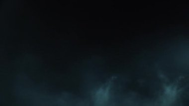 Atmosferik duman VFX elementi 4k ağır çekimde. Belirsiz bir geçmişi var. Toz, duman bulutu. Siyah arka planda duman. Beyaz duman siyah bg üzerinde sürünüyor.