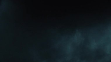Atmosferik duman VFX elementi 4k ağır çekimde. Belirsiz bir geçmişi var. Toz, duman bulutu. Siyah arka planda duman. Beyaz duman siyah bg üzerinde sürünüyor.