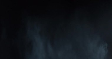 Atmosferik duman VFX elementi 4k ağır çekimde. Belirsiz bir geçmişi var. Toz, duman bulutu. Siyah arka planda duman. Beyaz duman siyah bg üzerinde sürünüyor.