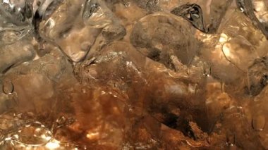 Yaz içkisi hazzının 4K ağır çekim görüntüsü. Soğuk, buzlu gazlı iksir. Bu ferahlatıcı kola, meyve suyu ya da elma şarabıyla susuzluğunuzu gidermek için kıvrımlar..