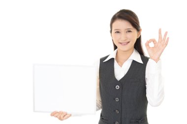 Gülen kadın elinde beyaz bir tahta tutuyor.