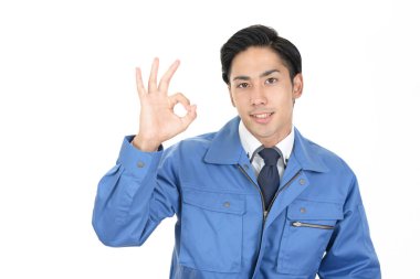 Gülümseyen genç erkek işçi, tamam işareti ile