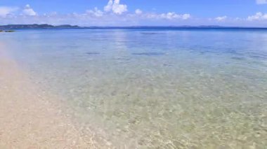 Mavi gökyüzü ve güzel dalgalarıyla deniz kenarında