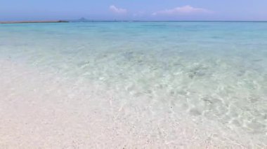 Mavi gökyüzü ve güzel dalgalarıyla deniz kenarında