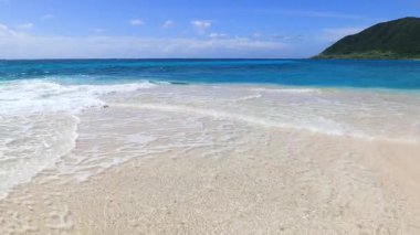 Mavi gökyüzü ve güzel dalgalarıyla deniz kenarında