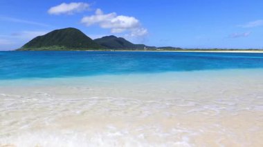 Mavi gökyüzü ve güzel dalgalarıyla deniz kenarında