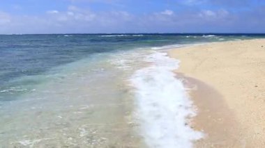 Mavi gökyüzü ve güzel dalgalarıyla deniz kenarında