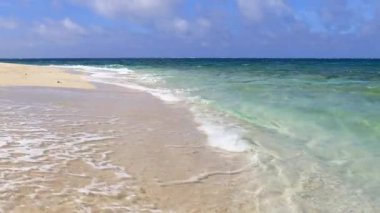 Mavi gökyüzü ve güzel dalgalarıyla deniz kenarında