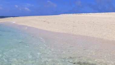 Mavi gökyüzü ve güzel dalgalarıyla deniz kenarında